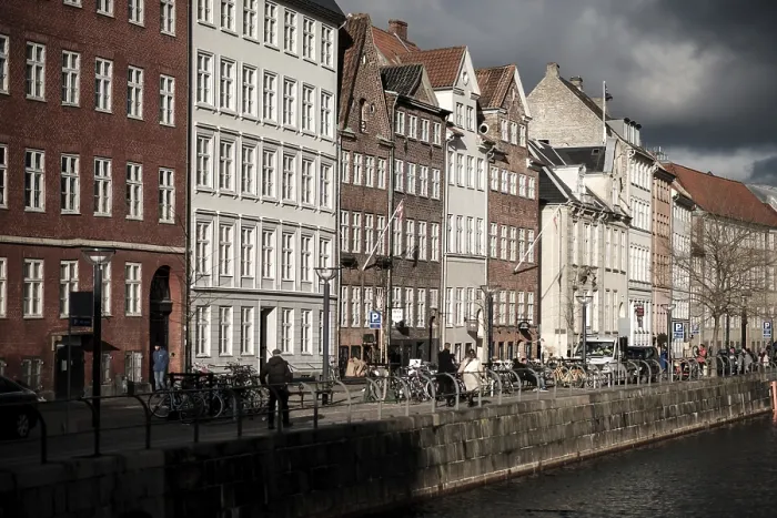 Framed Print : Sunlit row of historic buildings along a canal in a European city