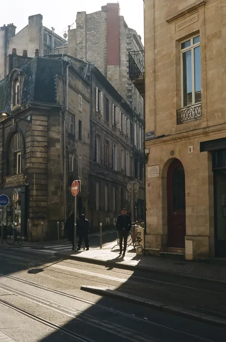 Framed Print : Sunlit street with historic buildings and people walking