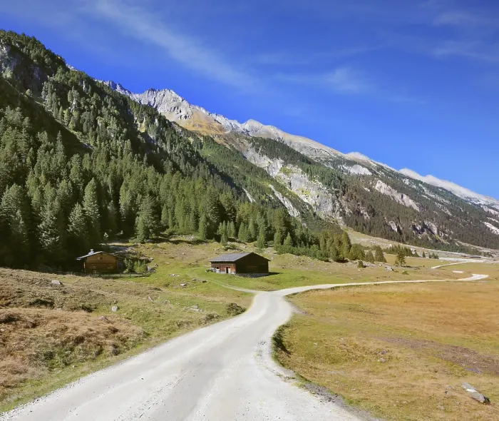 Framed Print : Sunny autumn day. Wide dirt road in an Alpine valley