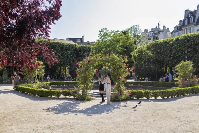Framed Print : A sunny garden in the city with trees and people out for a walk