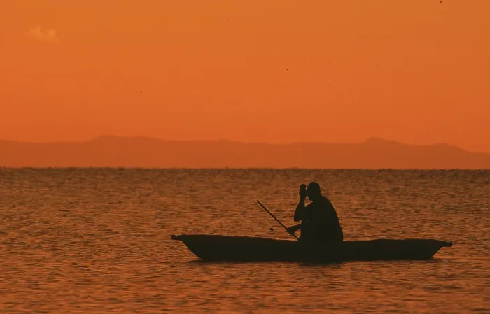 Framed Print : Sunrise over Lake Malawi, man in dugout Framed Print : Sunrise over Lake Malawi, man in dugout