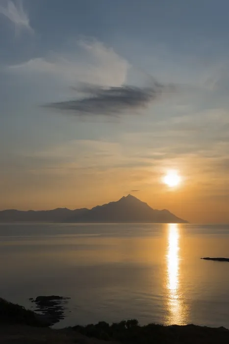 Framed Print : Sunrise over a mountain with clouds and reflections on the water surface