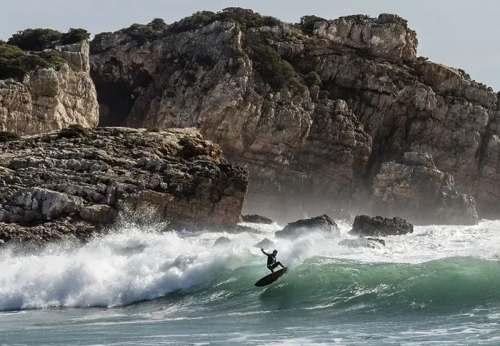 Framed Print : Surfer in the surf off the rocky coast
