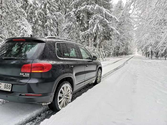 Framed Print : SUV driving in lane across heavily snow-covered road with lots of snow through a winter forest