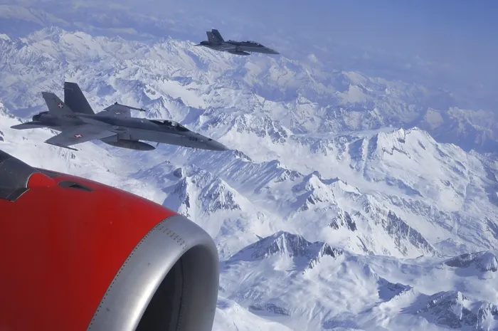 Framed Print : Swiss Air Force: Two FA-18 fighter aircraft escort a passenger plane over the Valais Alps