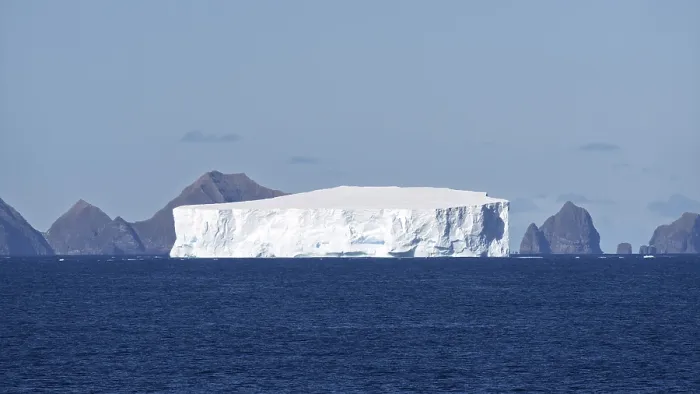 Framed Print : Table iceberg drifts off rocky coastal formations in the South Atlantic