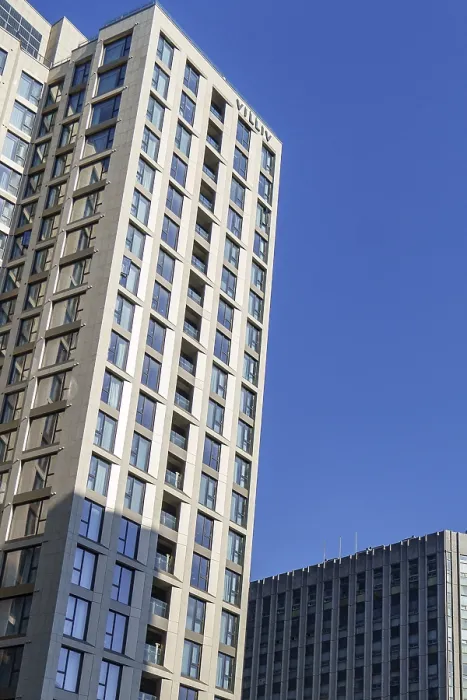 Framed Print : Tall modern building with many windows rising into the bright blue sky