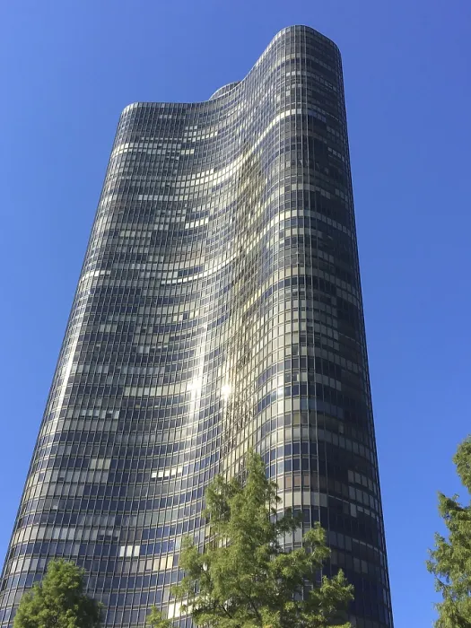 Framed Print : Tall modern wave design skyscraper against clear blue sky