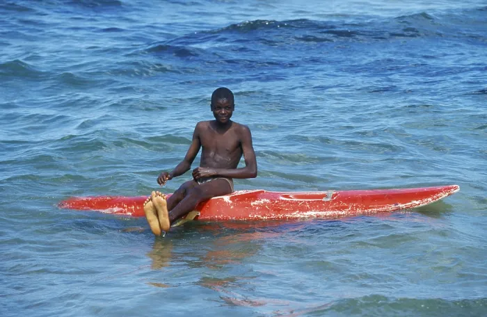 Framed Print : Teenager sitting on a surfboard in Lake Malawi Framed Print : Teenager sitting on a surfboard in Lake Malawi
