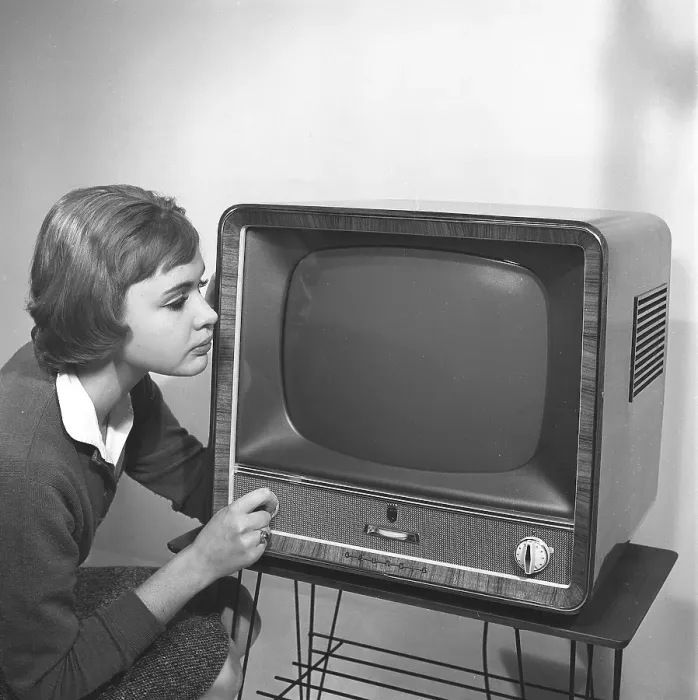 Framed Print : Television in the 1950s. A young woman is pictured beside a typical 50s television set Framed Print : Television in the 1950s. A young woman is pictured beside a typical 50s television set