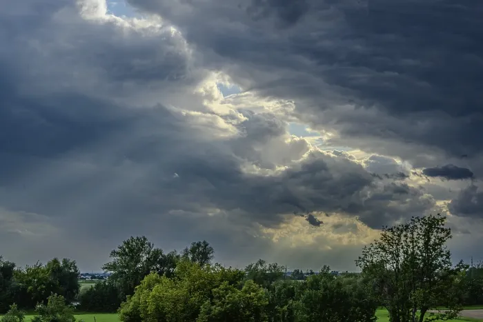 Framed Print : Thick, grey clouds cover the sky over a green landscape