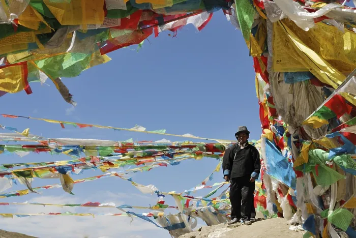 Framed Print : Tibetan man surrounded by prayer flags