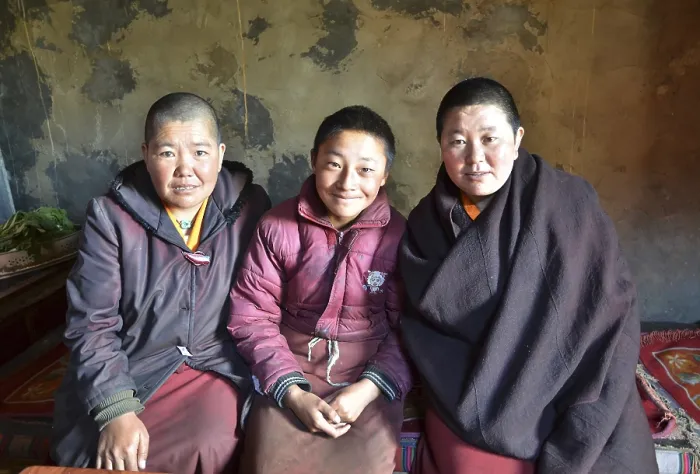 Framed Print : Three Tibetan nuns sitting in the kitchen of the nunnery in the mountains of Reting Monastery