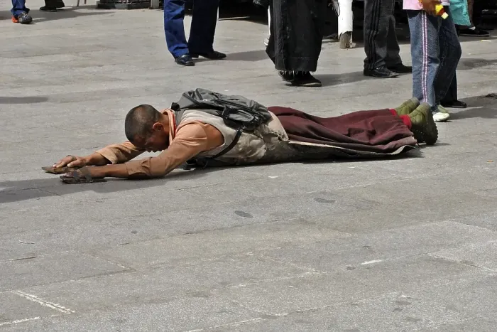 Framed Print : Tibetan pilgrim lies on the ground praying