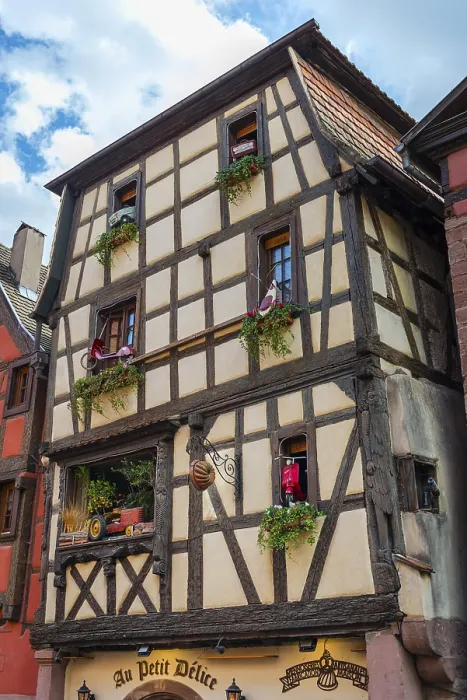 Framed Print : Timber-frame house decorated with vehicles in the historic old town of Riquewihr