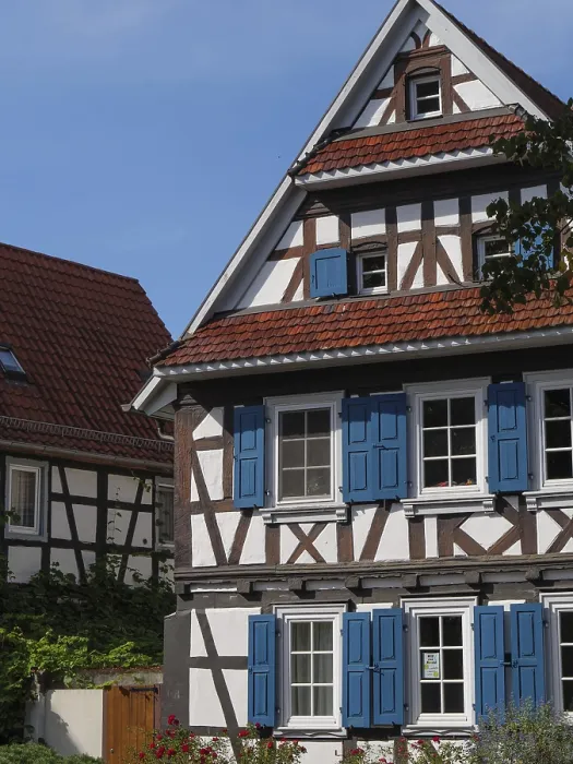 Framed Print : Timbered house with blue shutters under blue sky