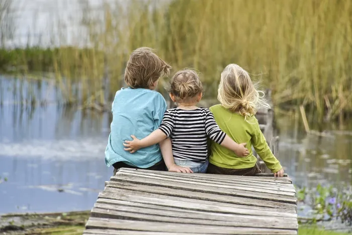 Framed Print : Three toddlers sitting together on an old jetty