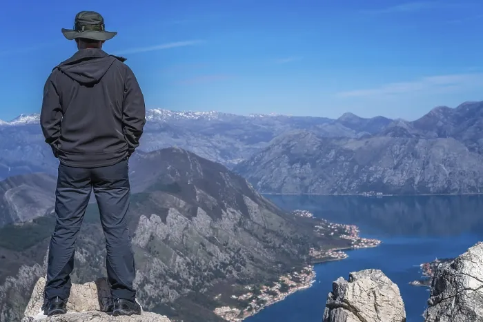 Framed Print : Tourist with a hat standing on a large boulder Framed Print : Tourist with a hat standing on a large boulder