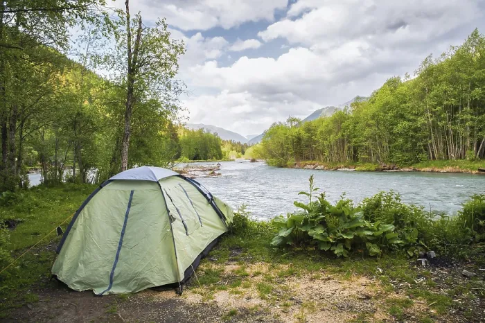 Framed Print : Tourist tent on the bank of a mountain river against the backdrop of mountains and high clouds Framed Print : Tourist tent on the bank of a mountain river against the backdrop of mountains and high clouds