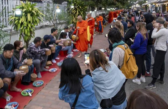 Framed Print : Tourists take pictures of monks during the Morning Alms ceremony