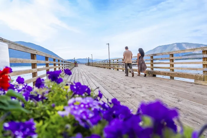 Framed Print : Tourists walking on a wooden pier adorned with vibrant flowers