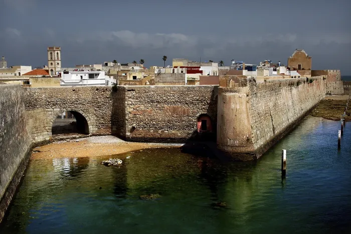 Framed Print : Towering fortress walls on the edge of a body of water