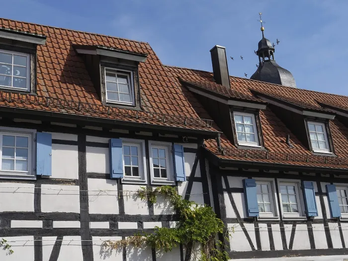 Framed Print : A traditional half-timbered house with a red tile roof under a clear blue sky