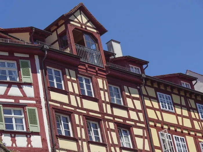 Framed Print : Traditional half-timbered house with red and yellow elements against a blue sky