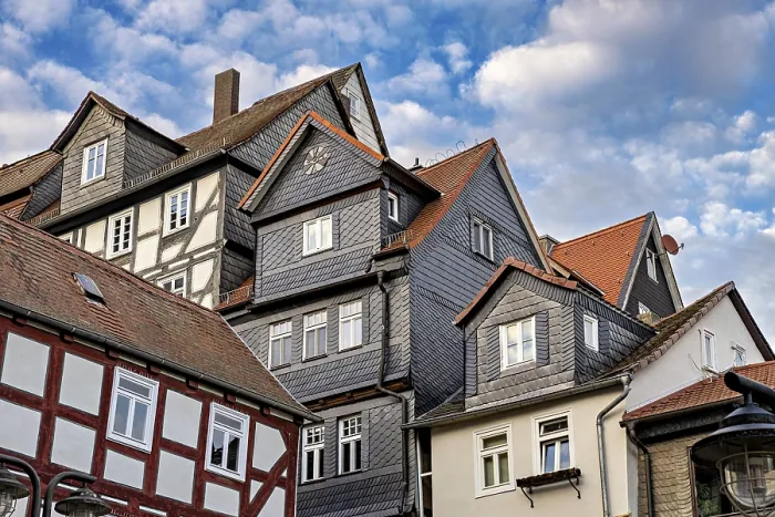 Framed Print : Traditional half-timbered houses with tiled roofs and cloudy skies