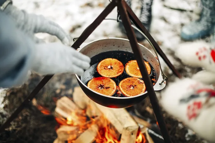 Framed Print : From above traditional mulled wine with slices of orange preparing in pot over burning logs in winter in countryside