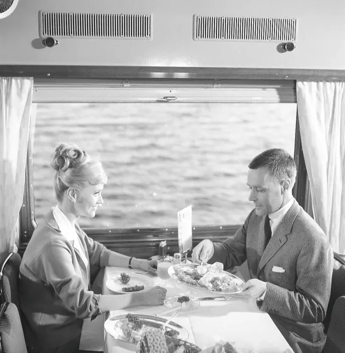 Framed Print : Train travel in the 1960s. A couple in the restaurant car of the train is enjoying dinner together. She has a typical 1960s hairstyle. 1964 Kristoffersson ref DD107-8