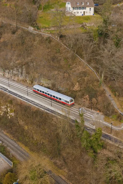 Framed Print : A train travels on a track through wooded hills in a wintry landscape