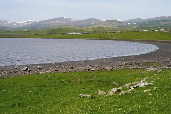 Framed Print : Tranquil lake with a view of green hills and distant mountains on the horizon