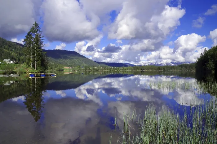 Framed Print : Tranquillity of a mirror-smooth lake surrounded by mountains and cloudy skies Framed Print : Tranquillity of a mirror-smooth lake surrounded by mountains and cloudy skies