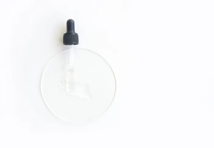 Framed Print : Transparent serum dropper on white surface with clear liquid for skincare and beauty treatments