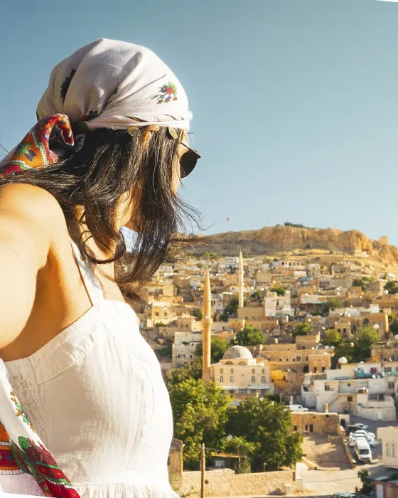 Framed Print : Traveler woman in white dress arms taking selfie self-portrait ooking over panoramic view of historic city of Mardin