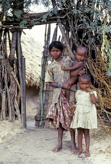 Framed Print : A tribal girl with her two sisters one standing nearby and another holding on her hip Framed Print : A tribal girl with her two sisters one standing nearby and another holding on her hip