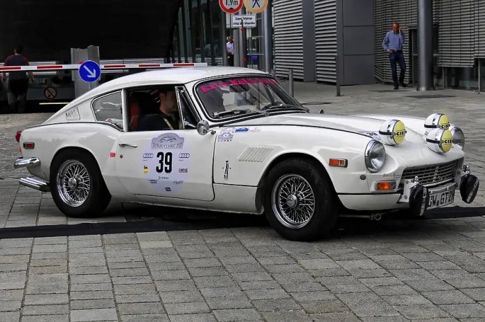 Framed Print : Triumph GT6, white classic car during a rally on cobblestones