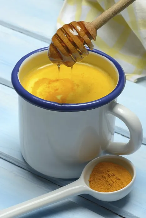 Framed Print : Turmeric milk in cup and honey spoon with draining bee honey and turmeric powder Framed Print : Turmeric milk in cup and honey spoon with draining bee honey and turmeric powder
