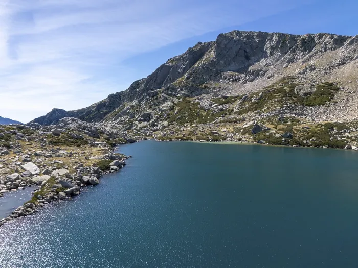 Framed Print : Turquoise alpine lake reflecting a clear sky surrounded by rocky slopes and small vegetation Framed Print : Turquoise alpine lake reflecting a clear sky surrounded by rocky slopes and small vegetation