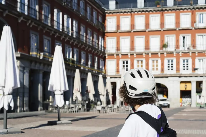 Framed Print : Unidentified female cyclist watching the closed terraces in Plaza Mayor of Madrid during coronavirus lockdown
