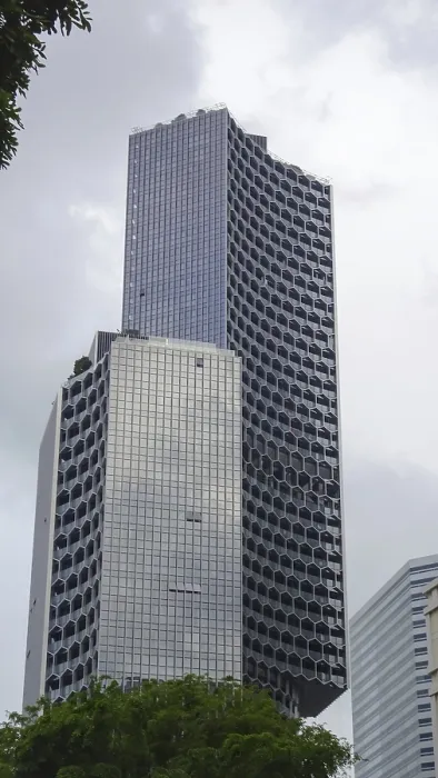Framed Print : Unique skyscraper with modern glass facade in an urban setting under cloudy sky Framed Print : Unique skyscraper with modern glass facade in an urban setting under cloudy sky