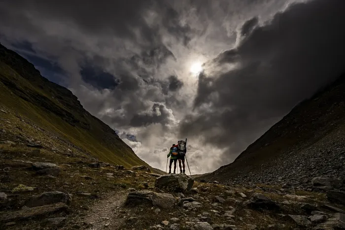Framed Print : Val Minor with mountaineers in autumn colours with dramatic cloudy sky