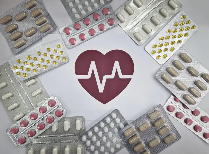 Framed Print : Various blister packs of pills arranged around a red heart symbol with an electrocardiogram