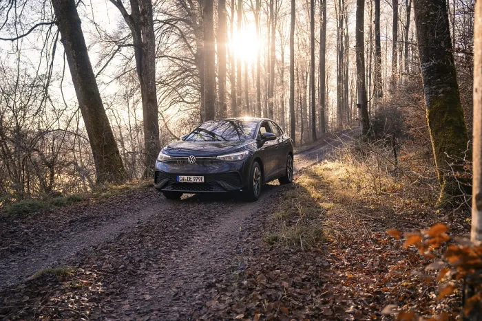 Framed Print : Vehicle on a forest path, illuminated by sunlight through the trees