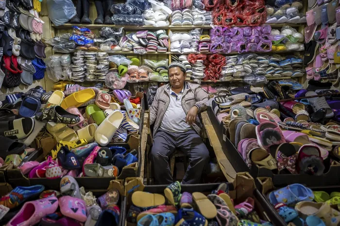 Framed Print : Vendor of shoes in his stall, very many shoes