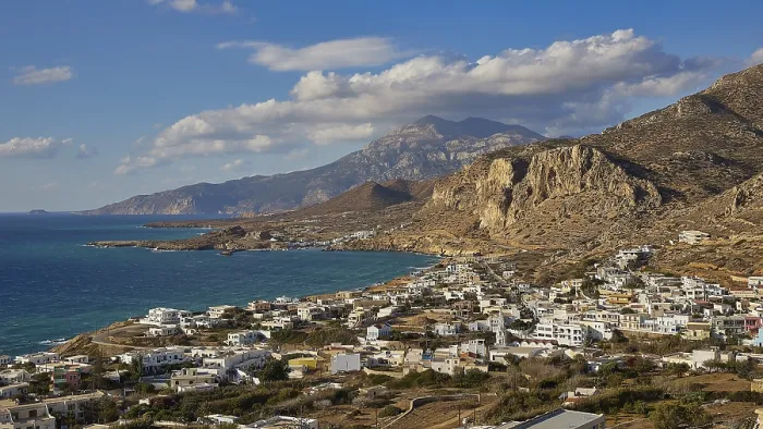 Framed Print : View over a coastal village against a mountain backdrop and blue sky Framed Print : View over a coastal village against a mountain backdrop and blue sky