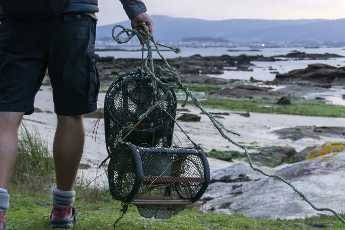 Framed Print : A detail view of fisherman with crab traps walking to the beach at low tide to go to work
