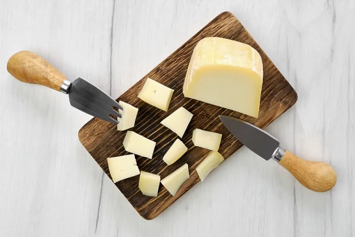 Framed Print : Top view of goat cheese cut on pieces on wooden cutting board Framed Print : Top view of goat cheese cut on pieces on wooden cutting board