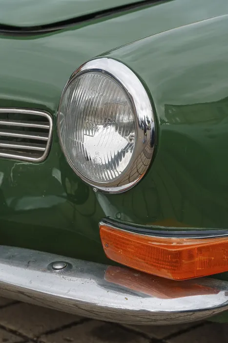 Framed Print : Front view of a green classic car with shiny headlights